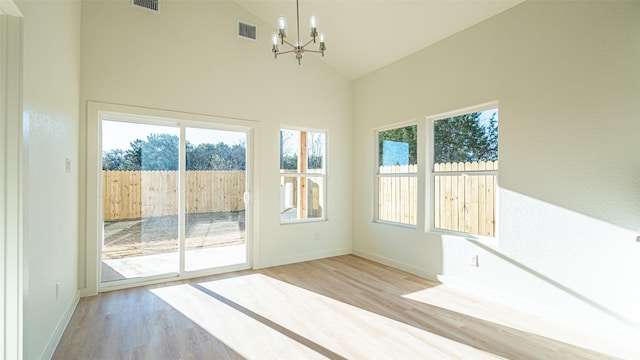 interior space featuring a notable chandelier, high vaulted ceiling, and light hardwood / wood-style flooring