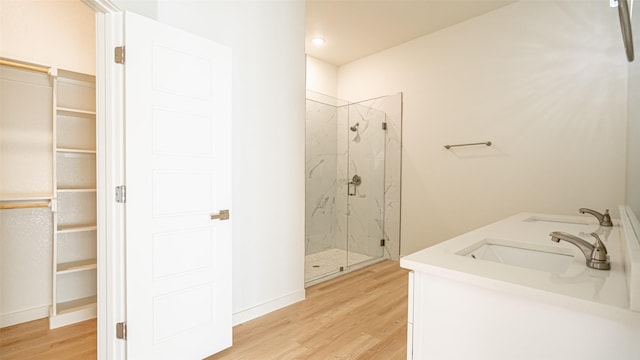 bathroom with vanity, a shower with shower door, and hardwood / wood-style floors