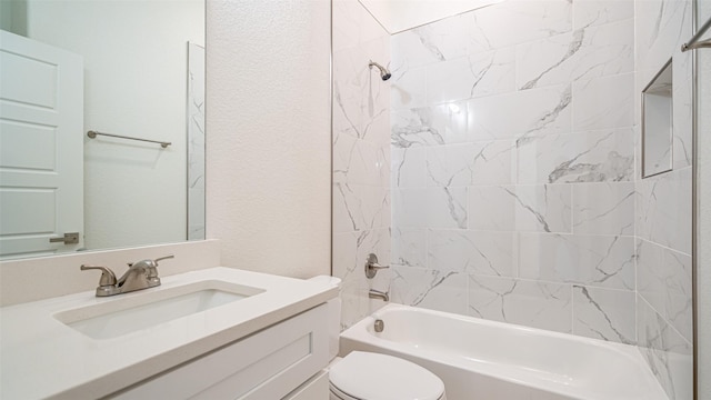 full bathroom featuring vanity, tiled shower / bath combo, and toilet