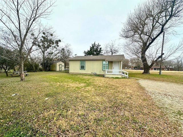 view of front facade featuring a front yard and a storage shed