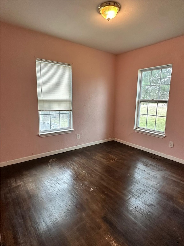 unfurnished room with dark hardwood / wood-style flooring