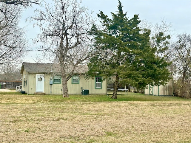 view of yard featuring cooling unit, a trampoline, and a shed