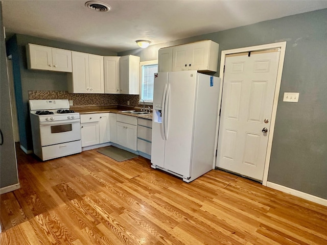 kitchen with white appliances, sink, light hardwood / wood-style flooring, and white cabinets