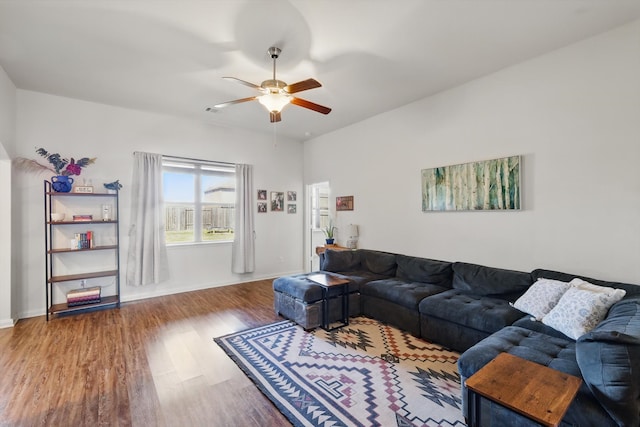 living room featuring a ceiling fan, baseboards, and wood finished floors