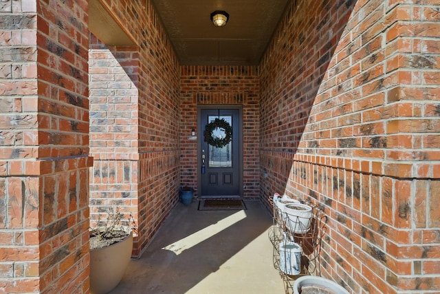 entrance to property featuring brick siding