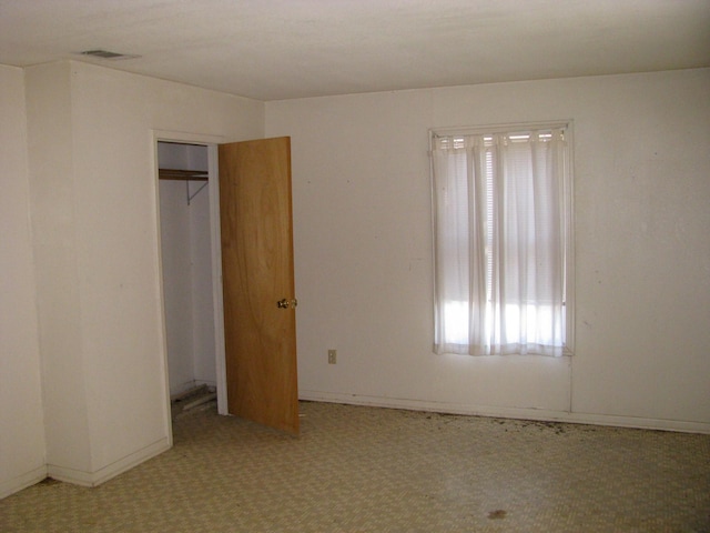 unfurnished bedroom with light colored carpet and a closet