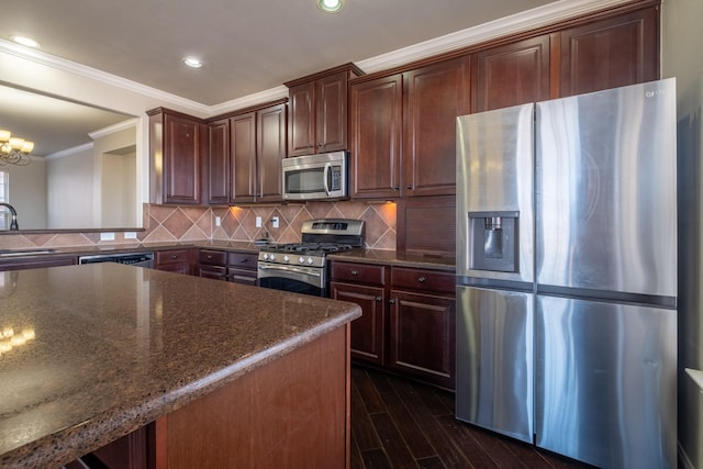 kitchen with sink, crown molding, appliances with stainless steel finishes, dark stone counters, and backsplash