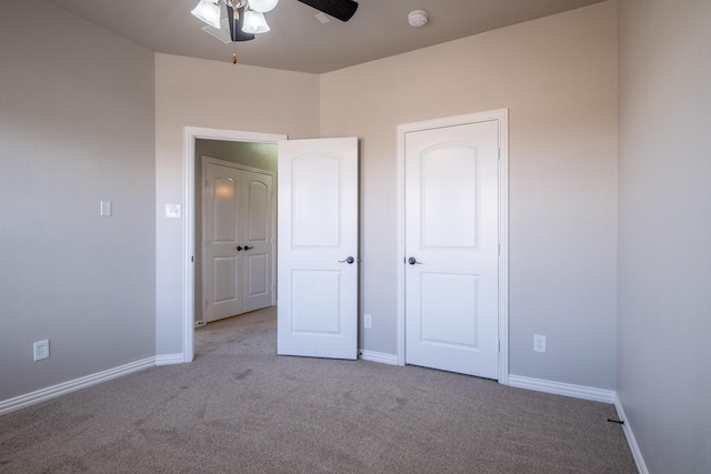 unfurnished bedroom with light colored carpet and ceiling fan