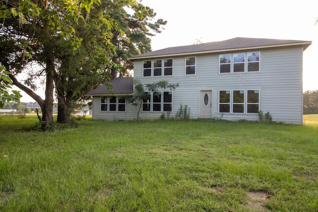 back of property featuring a lawn