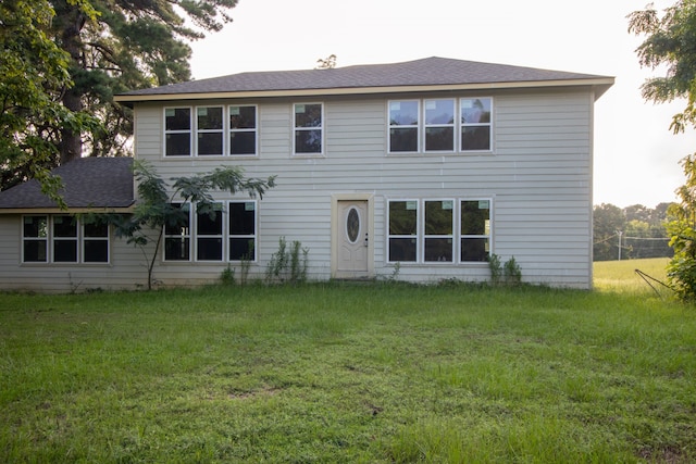 back of property featuring a lawn