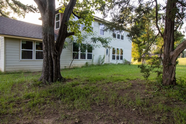 rear view of property featuring a lawn