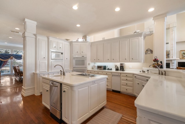 kitchen featuring white appliances, sink, an island with sink, and white cabinets