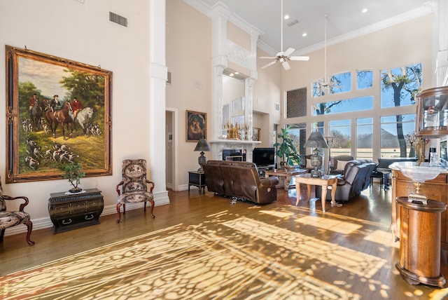 living room with hardwood / wood-style flooring, ceiling fan, and crown molding