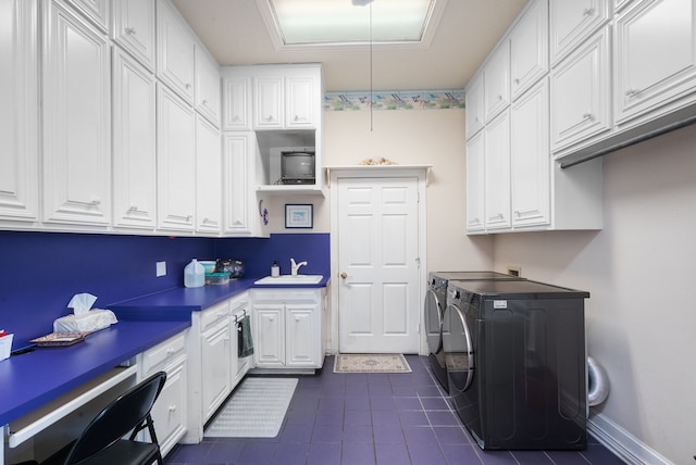 washroom with sink, washer and clothes dryer, cabinets, and dark tile patterned flooring