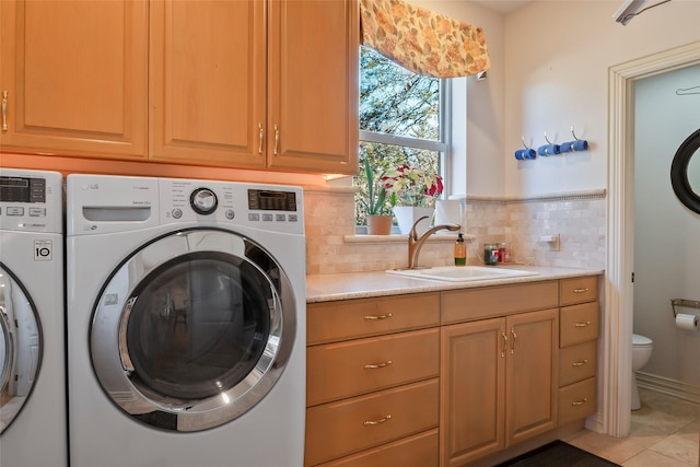 laundry room featuring cabinets, separate washer and dryer, and sink