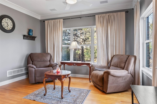 living area with crown molding, ceiling fan, and light hardwood / wood-style flooring