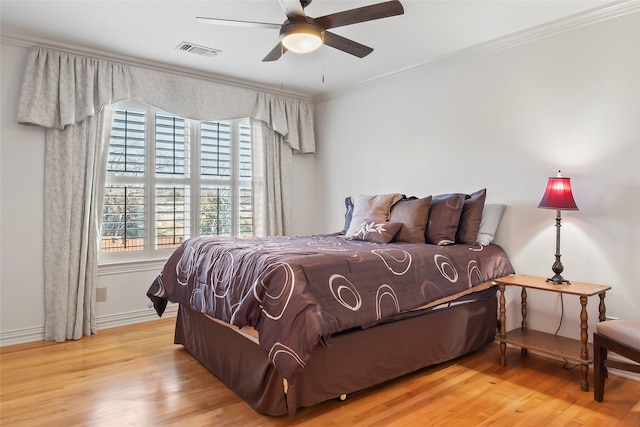 bedroom with crown molding, ceiling fan, and light wood-type flooring