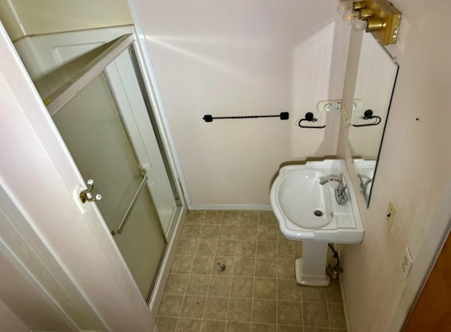 bathroom featuring sink and a shower with door