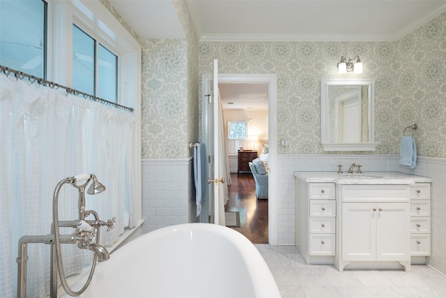 bathroom with vanity, a washtub, and tile walls