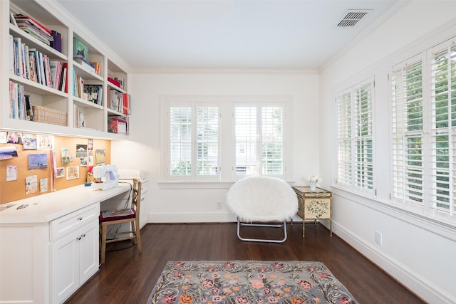 living area with ornamental molding, built in desk, and dark hardwood / wood-style flooring