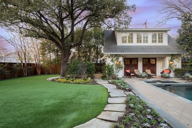 exterior space featuring a patio, an outdoor structure, a fenced in pool, and a lawn