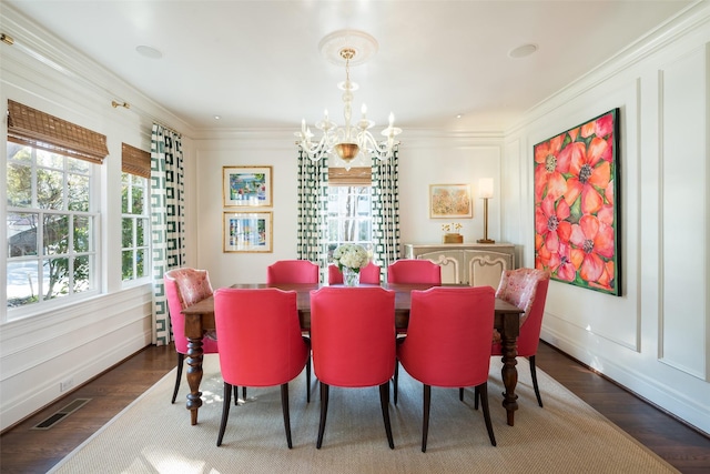 dining area featuring ornamental molding, dark hardwood / wood-style flooring, and a chandelier