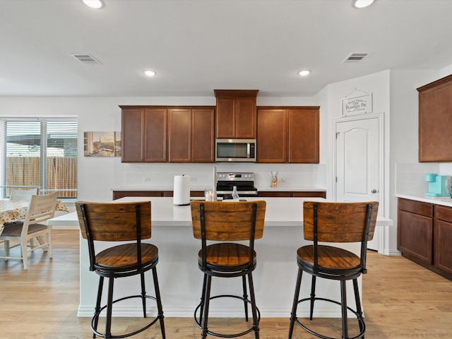 3224 Stillwater Ln, Aubrey, TX 76227 - kitchen with visible vents, decorative backsplash, a center island with sink, light countertops, and appliances with stainless steel finishes