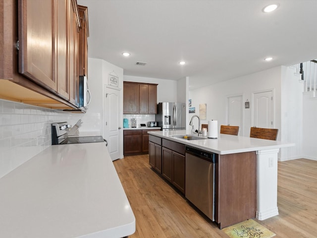 3224 Stillwater Ln, Aubrey, TX 76227 - kitchen featuring light wood finished floors, light countertops, appliances with stainless steel finishes, and a sink