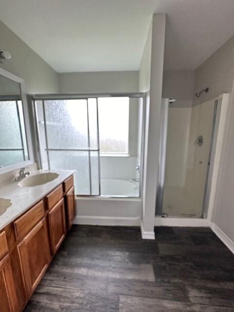 bathroom with hardwood / wood-style flooring, vanity, and separate shower and tub