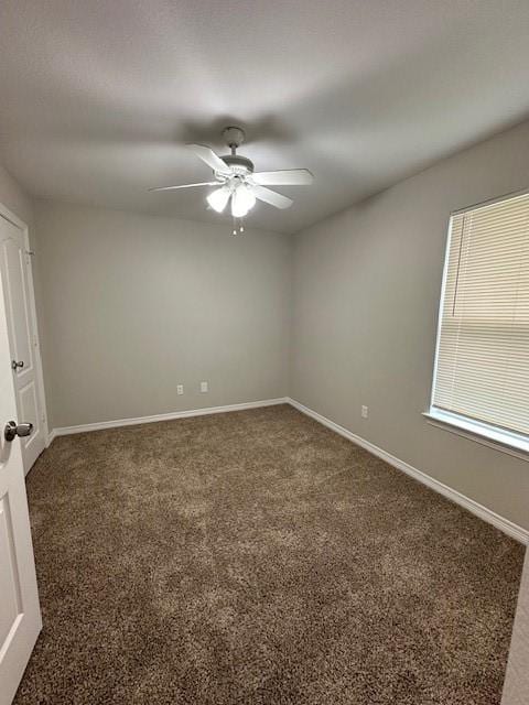 carpeted spare room featuring ceiling fan