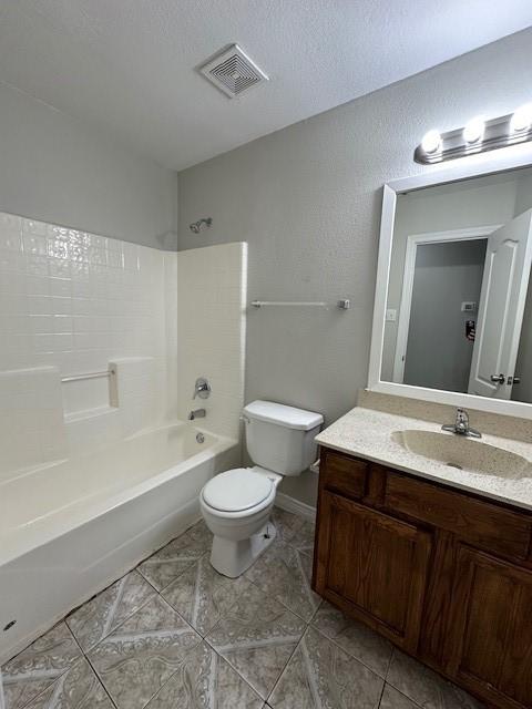 full bathroom with shower / bath combination, vanity, a textured ceiling, tile patterned floors, and toilet