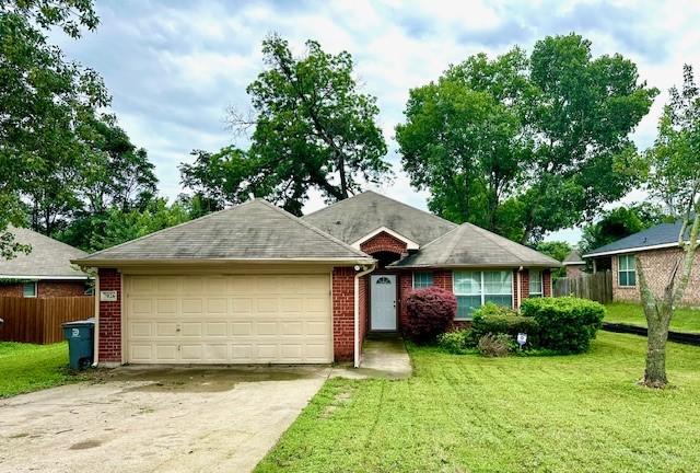 ranch-style home with a garage and a front lawn