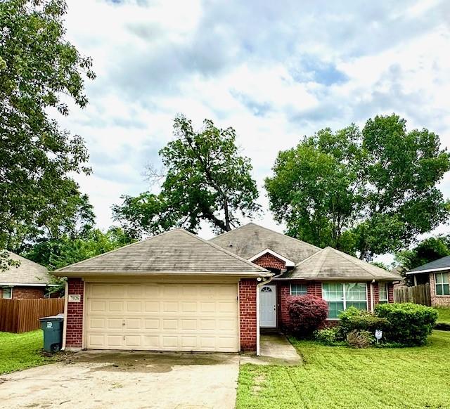 ranch-style home with a garage and a front lawn