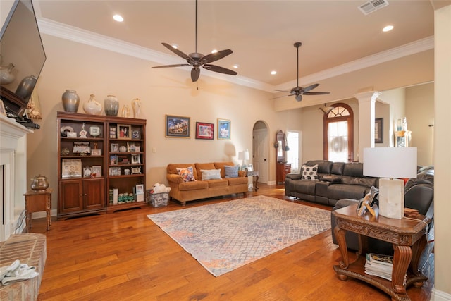 living room with crown molding, ceiling fan, light hardwood / wood-style floors, and ornate columns