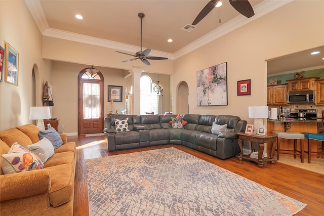 living room featuring crown molding, ceiling fan, and light wood-type flooring