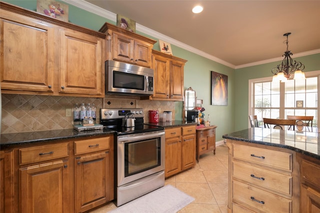 kitchen with crown molding, appliances with stainless steel finishes, dark stone countertops, and light tile patterned floors