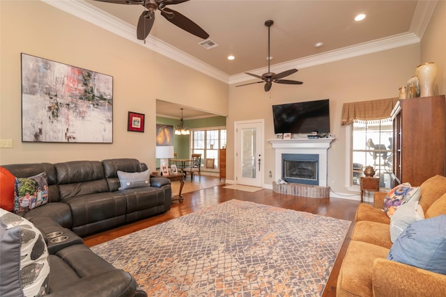 living room with hardwood / wood-style flooring, crown molding, and ceiling fan with notable chandelier