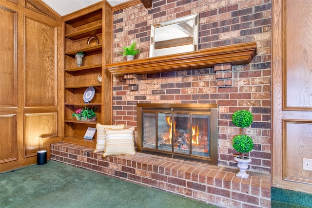 room details with a brick fireplace, built in shelves, and carpet flooring