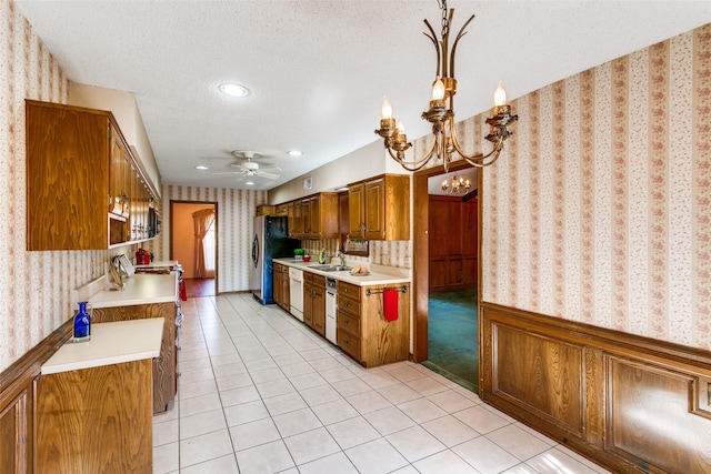 kitchen with pendant lighting, sink, stainless steel fridge, white dishwasher, and a textured ceiling