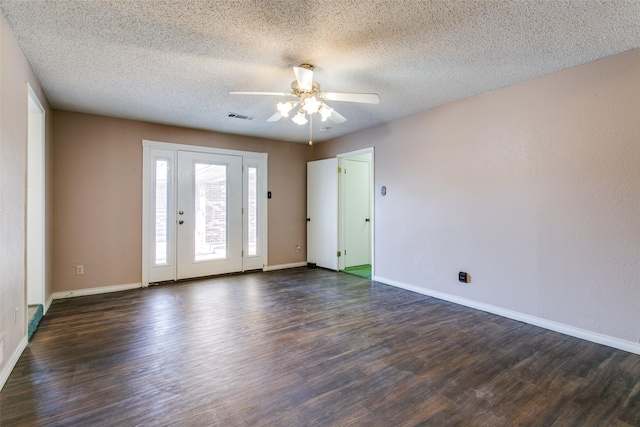 spare room featuring dark wood-type flooring, ceiling fan, and a textured ceiling