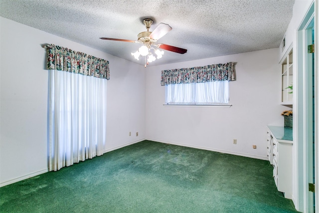 carpeted spare room featuring a textured ceiling and ceiling fan