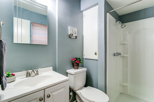 bathroom featuring walk in shower, vanity, and toilet