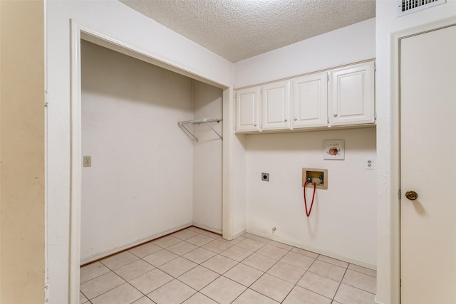 laundry room featuring gas dryer hookup, cabinets, hookup for a washing machine, electric dryer hookup, and a textured ceiling