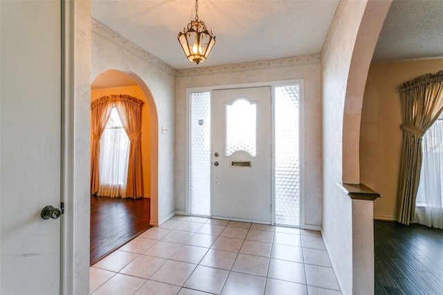 tiled entrance foyer featuring a healthy amount of sunlight and a textured ceiling