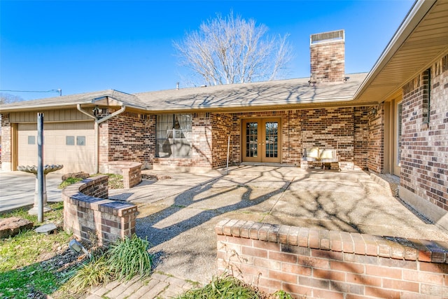 rear view of house with a patio, a garage, and french doors