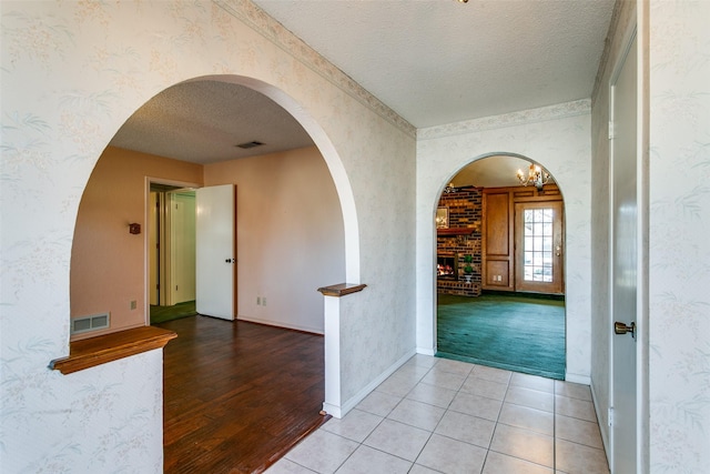 hall featuring tile patterned flooring and a textured ceiling