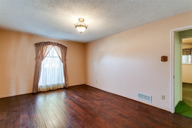 unfurnished room featuring dark hardwood / wood-style floors and a textured ceiling