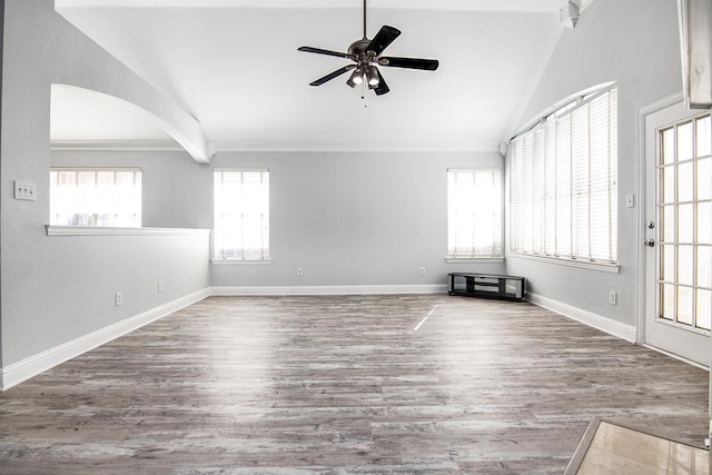 empty room featuring hardwood / wood-style flooring, ornamental molding, lofted ceiling, and ceiling fan