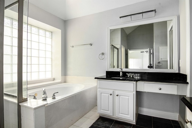 bathroom with plenty of natural light, plus walk in shower, tile patterned flooring, and vanity