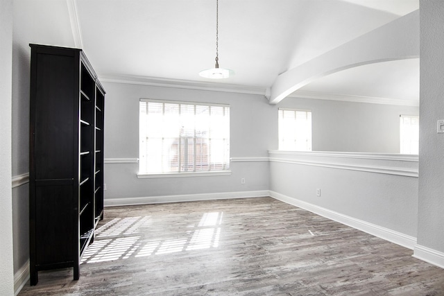 spare room featuring hardwood / wood-style flooring, crown molding, and lofted ceiling